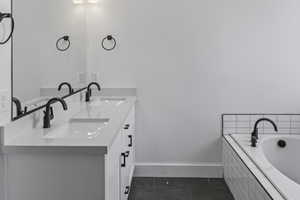 Full bathroom featuring double vanity, a garden tub, and dark tile patterned flooring