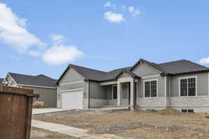 View of front of home with a porch, an attached garage, driveway, and a shingled roof