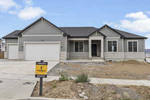 Craftsman inspired home with covered porch, concrete driveway, a garage, and a shingled roof