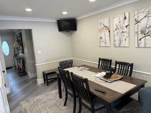 Dining area featuring crown molding, wood finished floors, and recessed lighting