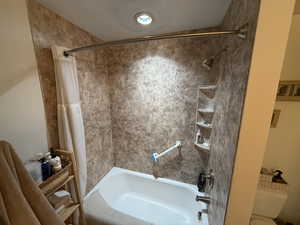 Full bath featuring shower / bath combo with shower curtain and toilet