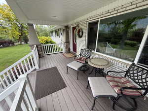 Wooden porch featuring a lawn