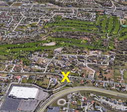 Aerial view of property's location with nearby suburban area