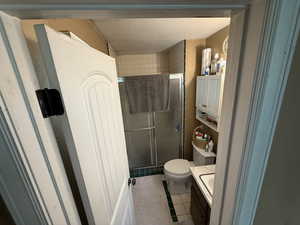 Bathroom featuring vanity, a stall shower, light tile patterned flooring, and a textured ceiling