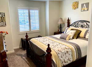 Bedroom featuring dark carpet and baseboards