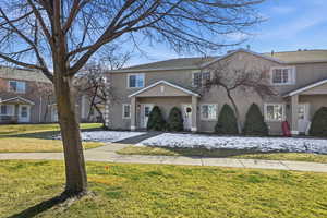 Traditional-style house featuring a front lawn and stucco siding