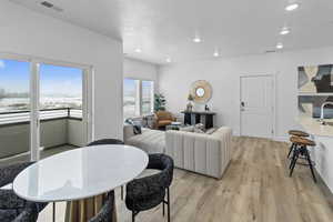 Dining room with light wood finished floors and recessed lighting
