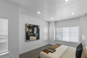 Bedroom featuring carpet flooring, a textured ceiling, and recessed lighting