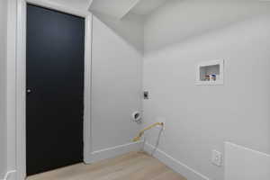 Laundry room featuring light wood-style flooring, washer hookup, and electric dryer hookup
