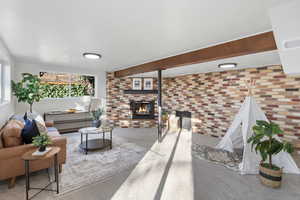 Carpeted living area featuring brick wall, a fireplace, beamed ceiling, and baseboard heating