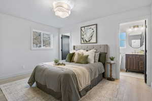 Bedroom featuring light wood finished floors and connected bathroom