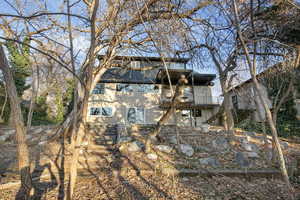 Rear view of property featuring brick siding and a balcony