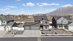View of front of home featuring a gate, concrete driveway, a residential view, a garage, and stone siding