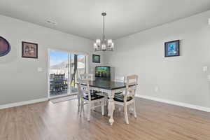 Dining room with hanging lights and light wood-style flooring