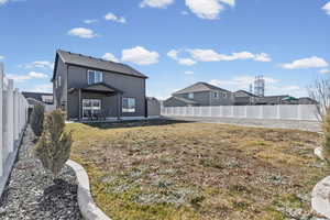 Rear view of house featuring a patio and a fenced backyard