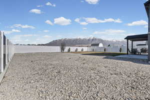 Fenced backyard featuring a mountain view and a patio area