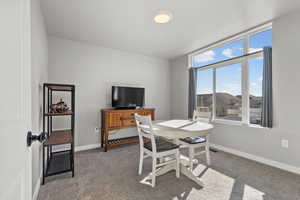 Carpeted office space with baseboards