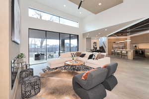 Living area with recessed lighting, a high ceiling, and ceiling fan