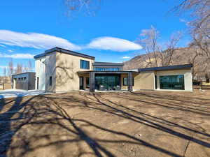 View of front of house featuring a patio area and an outbuilding
