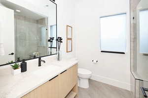 Bathroom with walk in shower, vanity, and recessed lighting