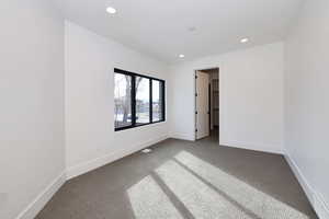 Unfurnished bedroom featuring carpet flooring, recessed lighting, and a baseboard radiator