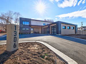 View of building exterior with an attached garage and asphalt driveway