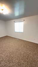 Spare room with baseboards and a textured ceiling