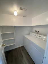 Laundry area featuring separate washer and dryer, dark wood finished floors, and a textured ceiling
