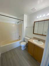 Bathroom with vanity, shower / bathtub combination, and wood finish floors