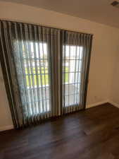 Spare room with baseboards and dark wood-style floors