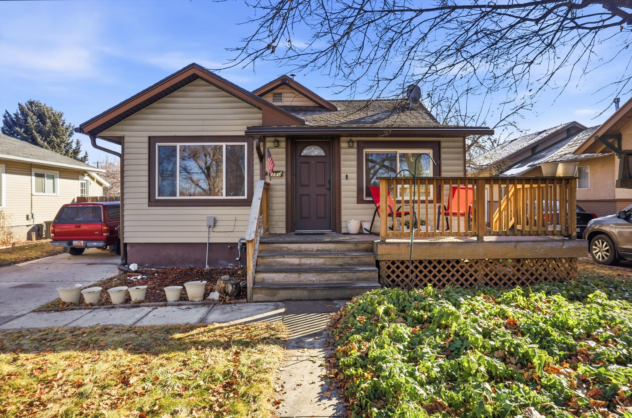Bungalow with a shingled roof and wooden deck