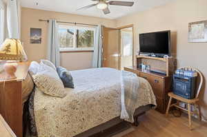 Primary bedroom featuring ceiling fan and wood finished floors