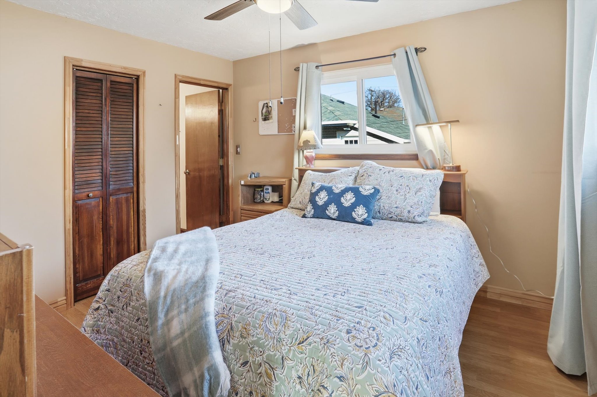 Primary bedroom with a closet, wood finished floors, and ceiling fan