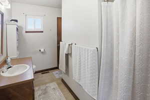 Bathroom featuring vanity, a shower with shower curtain, and light tile patterned floors