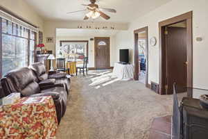 Living area with a ceiling fan and carpet floors