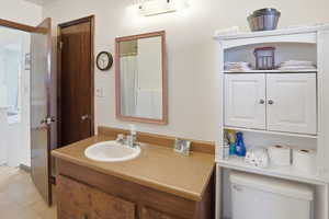 Three quarter primary walk thru bath featuring a shower with curtain and vanity.