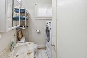 Half bathroom with washer / dryer and vanity