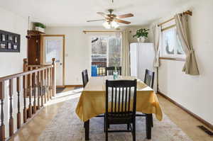 Dining space with ceiling fan and light tile patterned flooring