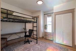 Bedroom with light wood-type flooring, two closets, and an office area