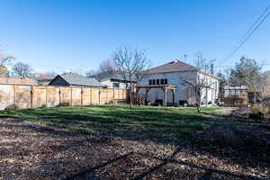 Back of house featuring a pergola, a fenced backyard, a patio area, and roof with shingles