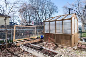 View of yard with a garden, an outbuilding, and a sunroom