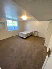 Bedroom featuring dark carpet and baseboards