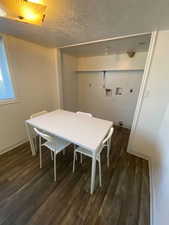 Dining room featuring dark wood-style flooring and a textured ceiling