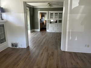 Hallway with crown molding and dark wood-style floors