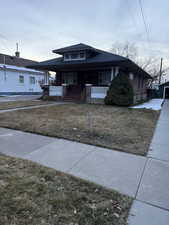 Bungalow-style house with covered porch and a front yard