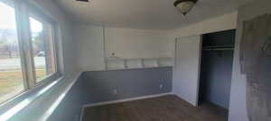 Unfurnished bedroom with a closet and dark colored carpet