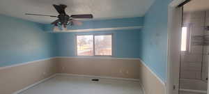 Spare room with ceiling fan and a textured ceiling