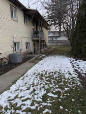 Snow covered property with a balcony and brick siding