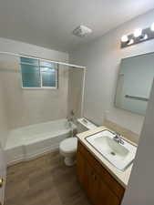 Full bath with vanity, bathing tub / shower combination, and dark wood-style flooring