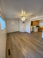 Unfurnished living room with dark wood-type flooring and a ceiling fan